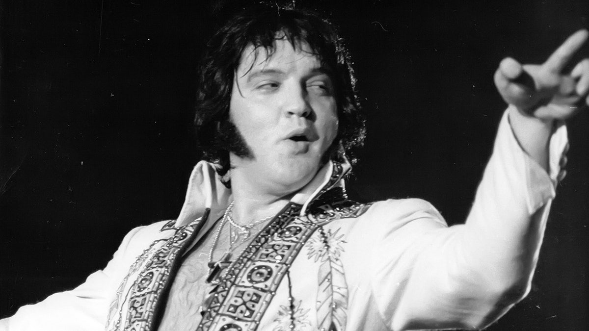 Elvis Presley cantando com um macacão branco