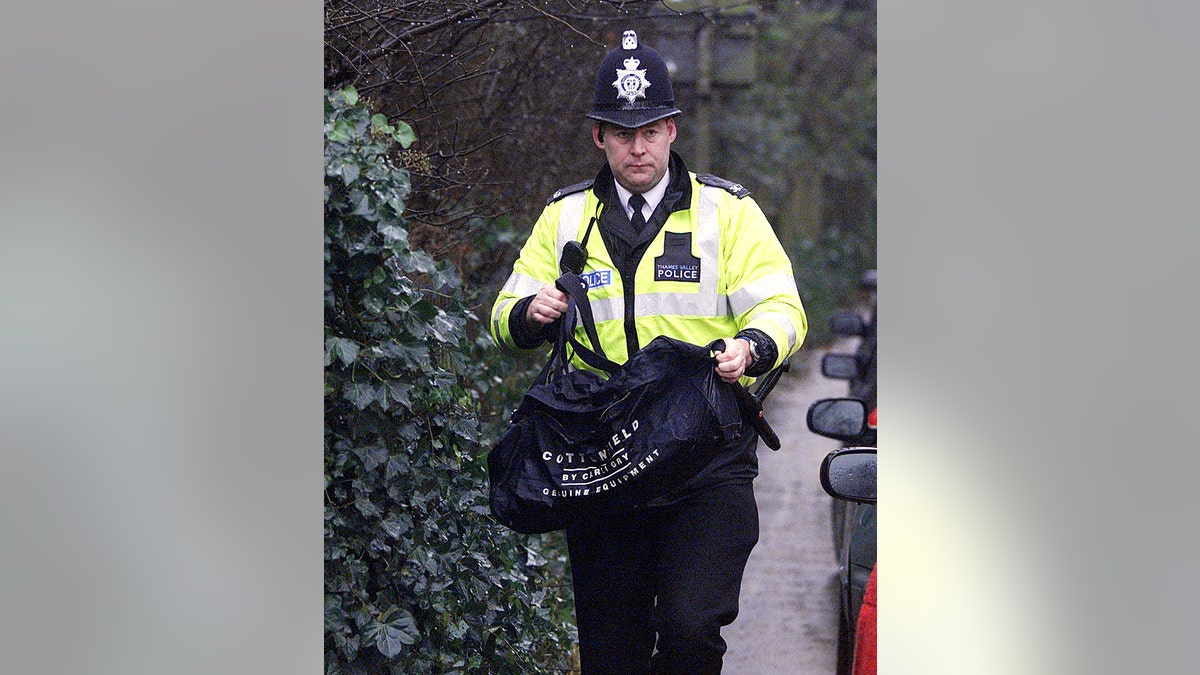 A close-up of a policeman in uniform holding a duffel bag