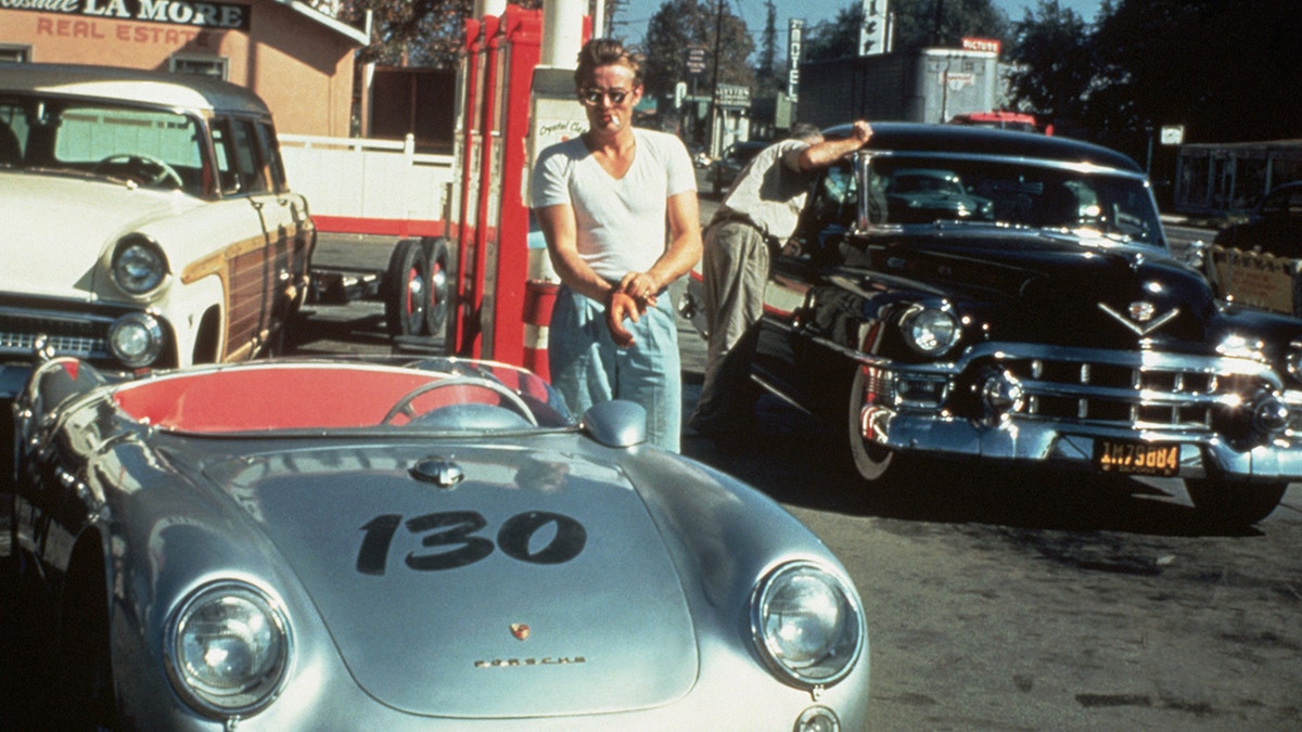 James Dean at a gas station with his silver Porsche 550 Spyder