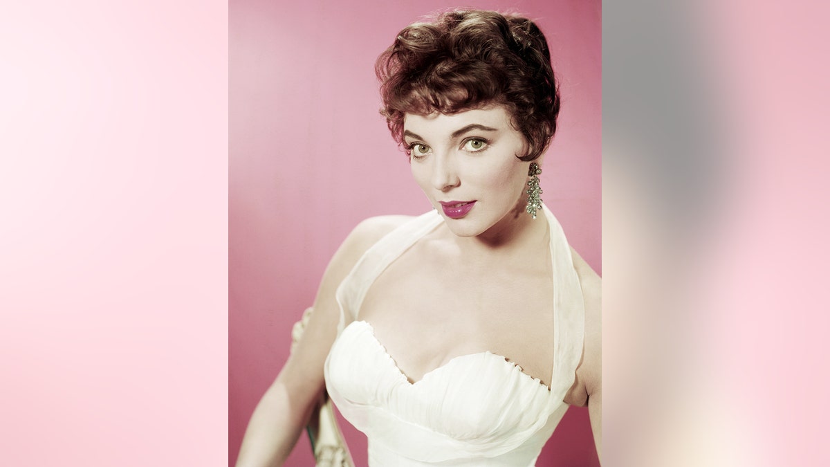 Joan Collins in a white evening dress