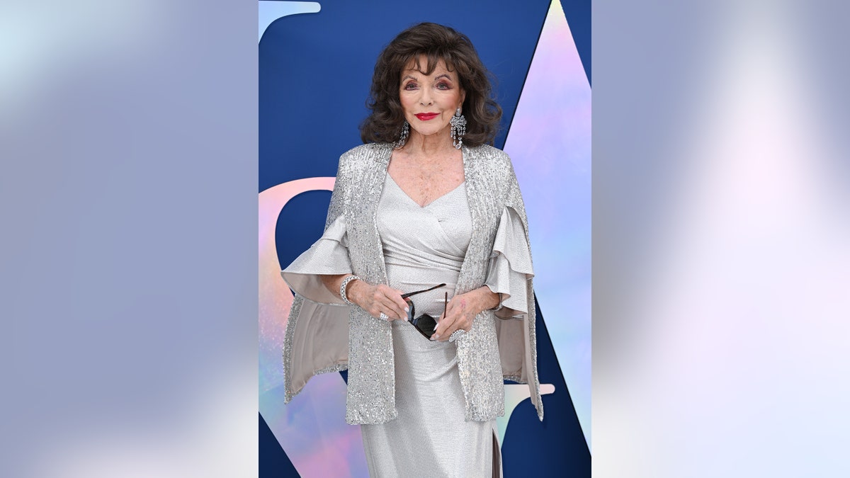 Joan Collins wearing a silver dress