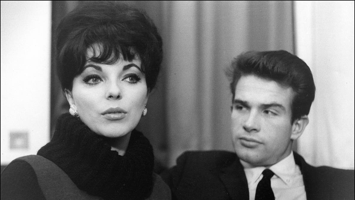 Warren Beatty looking sternly at Joan Collins in a black and white photo of them