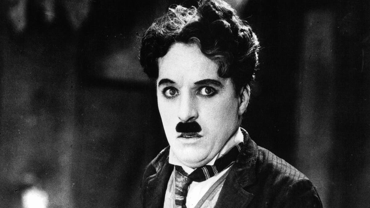 A close-up of Charlie Chaplin dressed as The Tramp looking worried