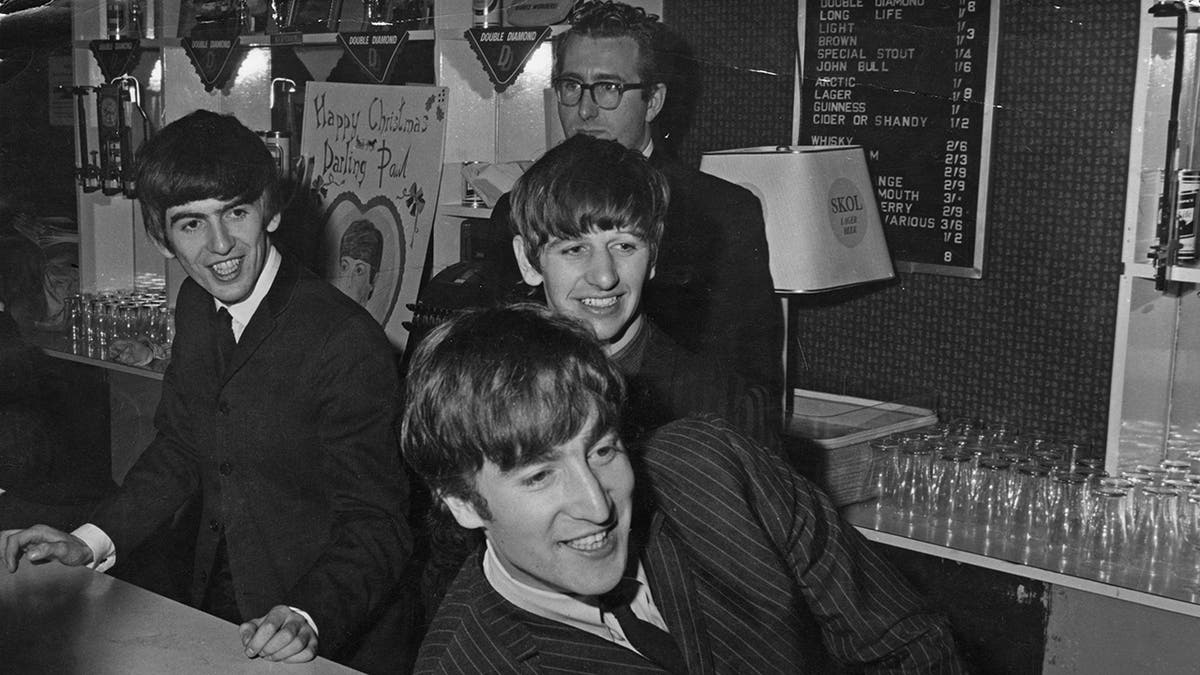 Mal Evans standing behind The Beatles as theyre smiling