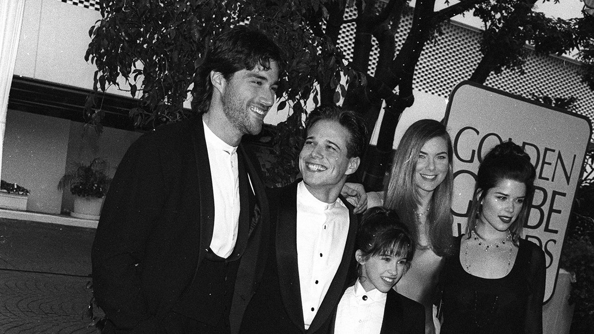 The Party of Five cast together and smiling on the red carpet in a black and white photo