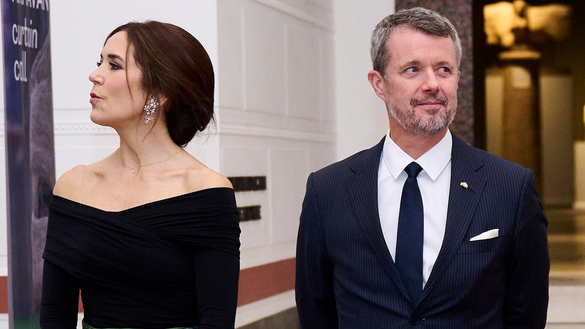 Princess Mary and Prince Frederik standing shoulder to shoulder and facing away from each other