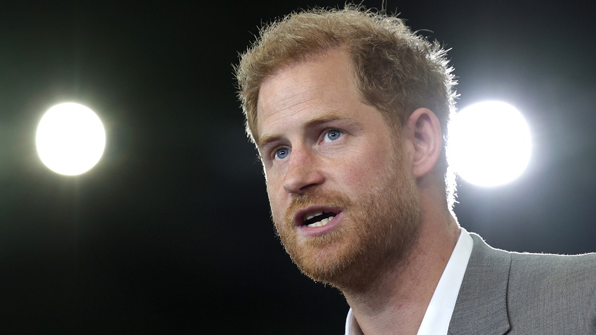 A close-up of Prince Harry giving a speech against a black backdrop