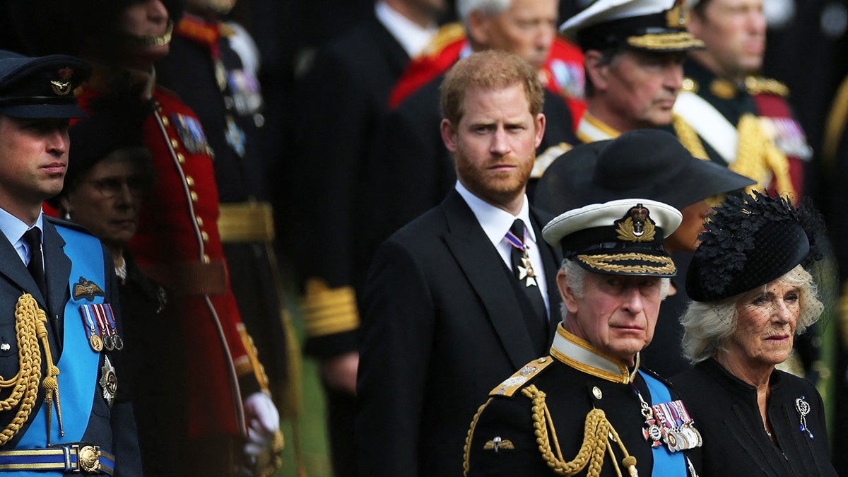 Prince Harry looking somber next to King Charles and Queen Camilla