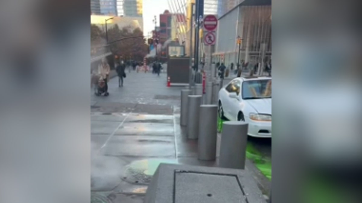 Bright green water leaking out of New York City sewers onto street by cars