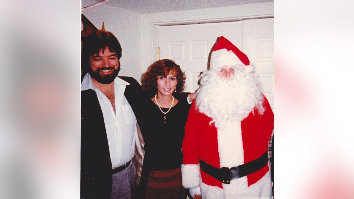 Coronel Tom Parker em traje de Papai Noel ao lado de Greg McDonald e sua esposa