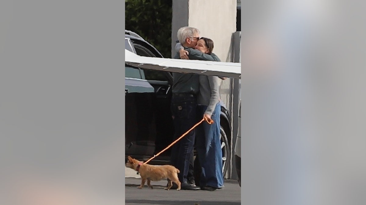 Harrison Ford e Calista Flockhart se abraçando no aeroporto