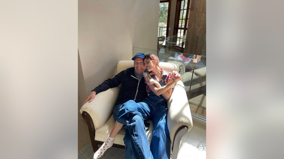 Tallulah Willis sitting with Bruce Willis in a chair