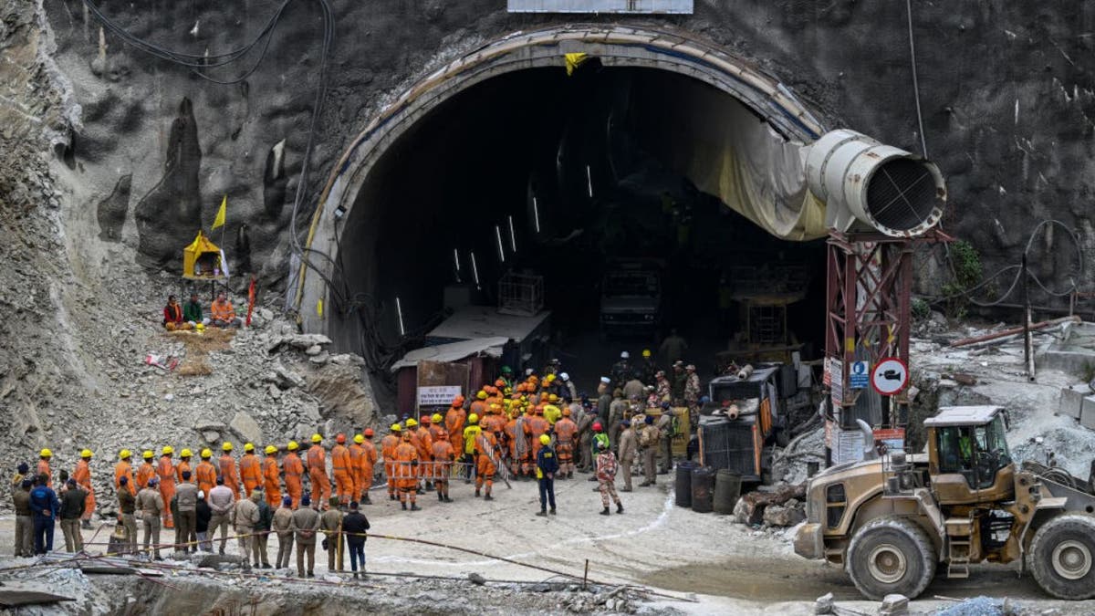 Rescue workers lined up outside a tunnel in India where men are traped