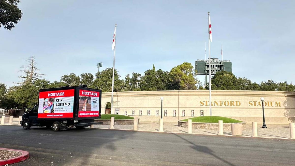 A truck displaying the names and photos of Israeli children taken as hostages by Hamas drives past Stanford University