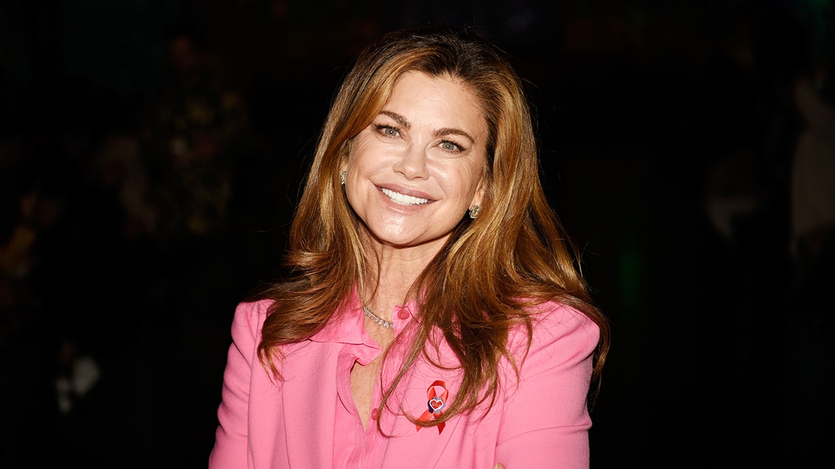 Kathy Ireland smiling and wearing a pink suit