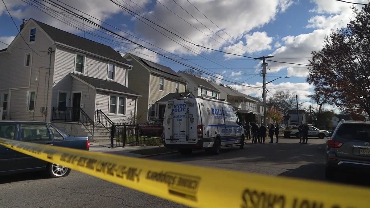 Police tape and a polie van outside a house in New York City where three people were fatally stabbed