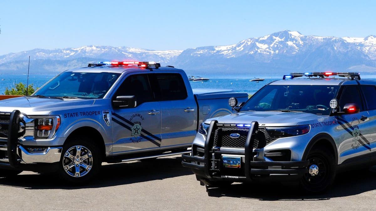 Two Nevada State Trooper vehicles parked with mountains in the background