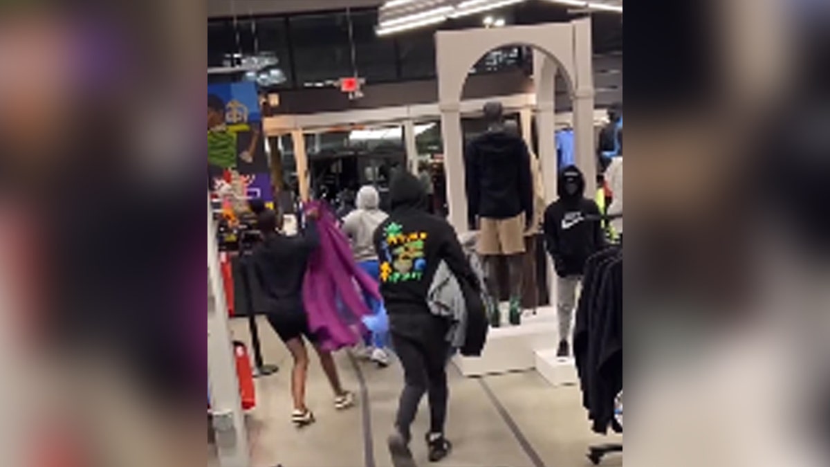 Robbers exiting Nike store with clothes they stole