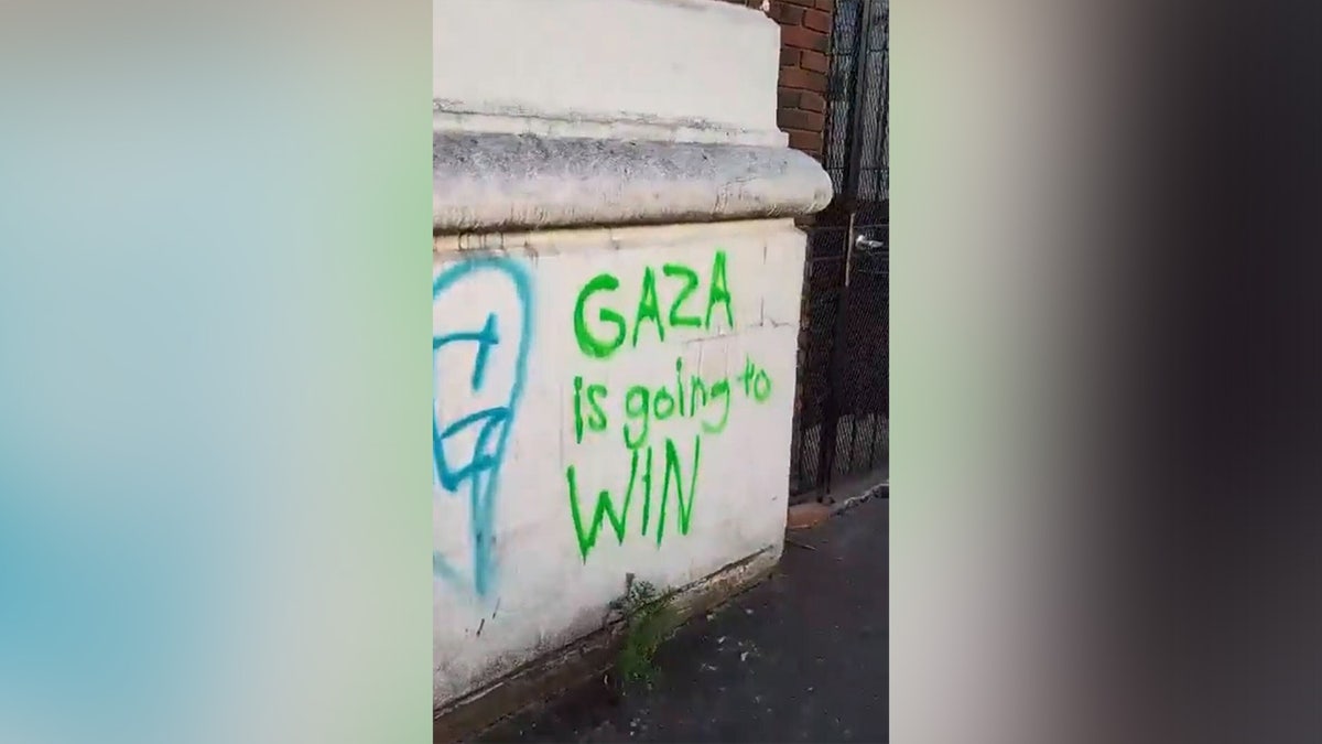 reading graffiti, "Gaza will win" 