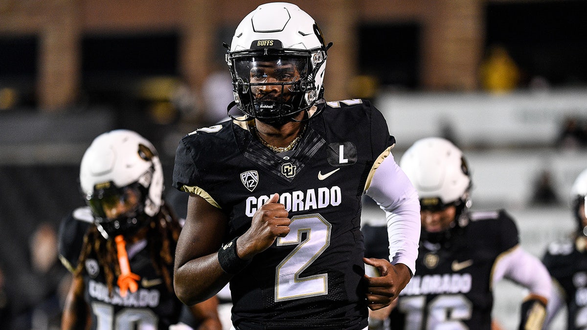 Shedeur Sanders runs onto the field