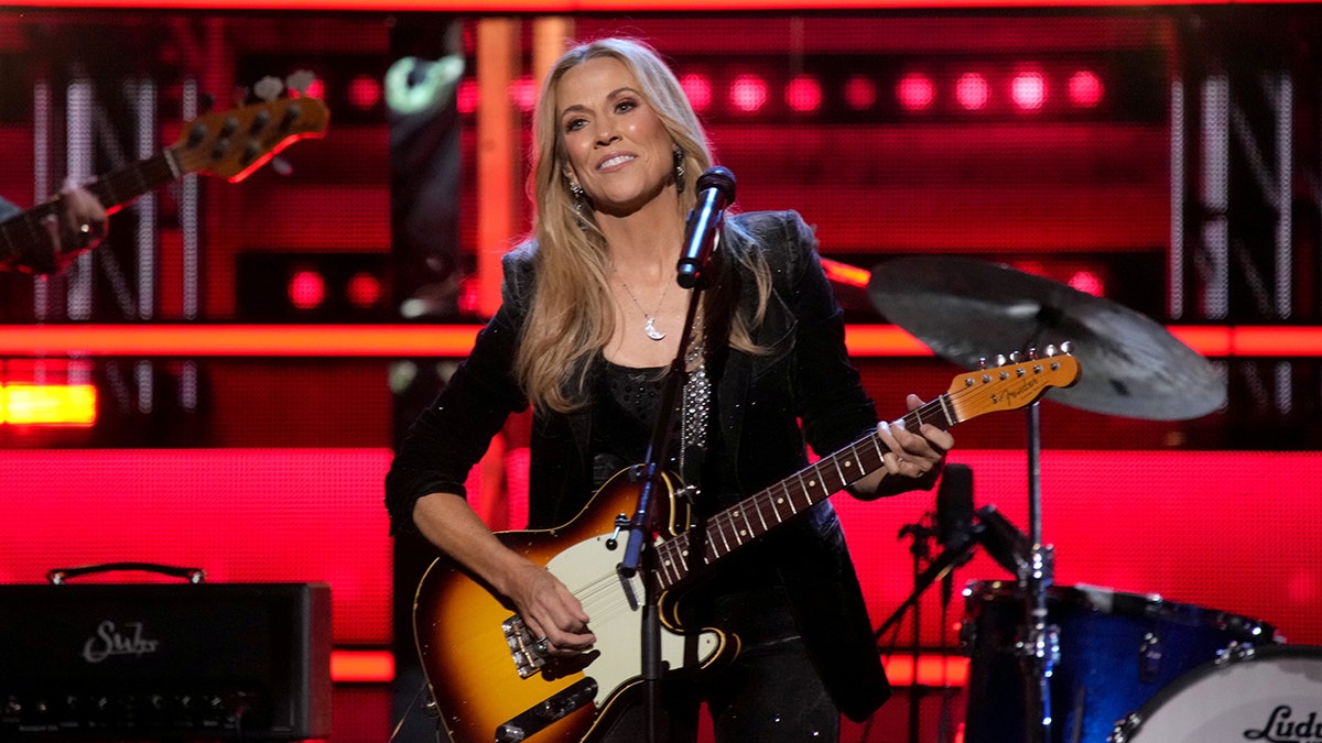 Sheryl Crow performing on stage with guitar