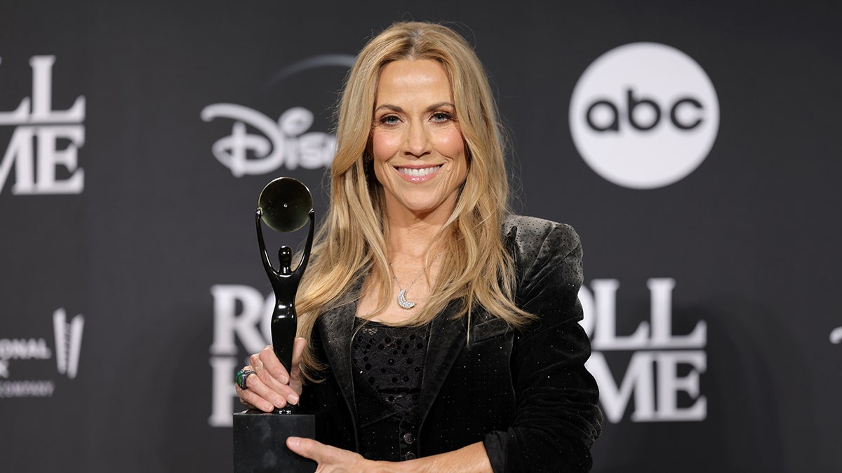 Sheryl Crow holding her award for her induction into the Rock & Roll Hall of Fame