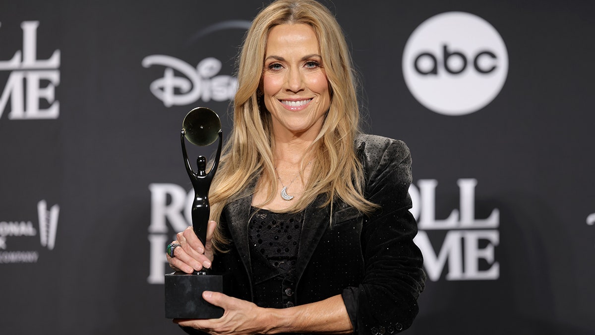 Sheryl Crow holding her award for her induction into the Rock & Roll Hall of Fame