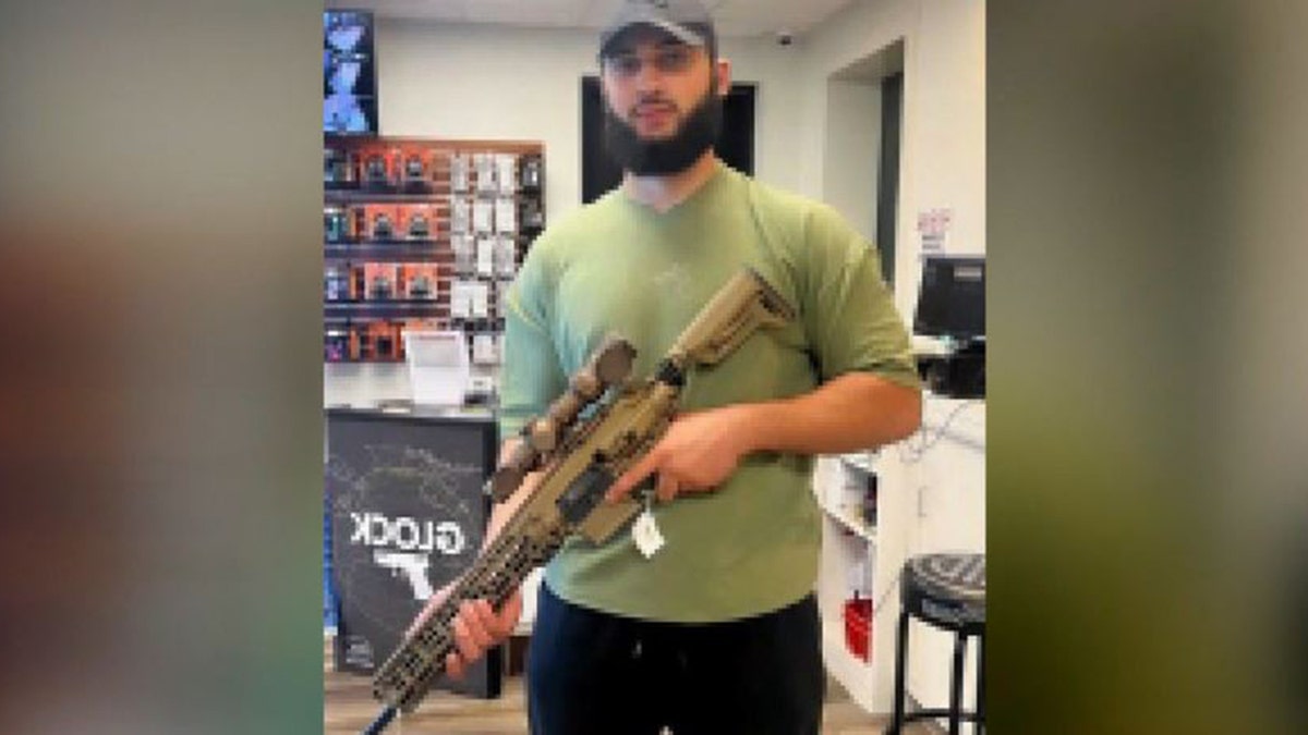 Sohaib Abuayyash posing with large rifle