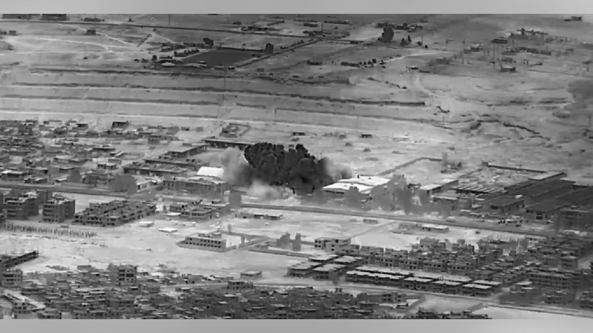 Black and white image of an airstrike on a weapons storage building in Syria