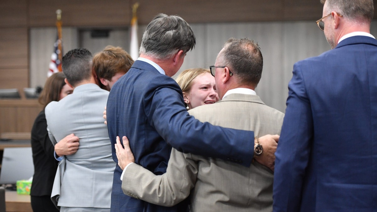 Maya Kowalski cries while hugging her attorneys at the conclusion of her trial