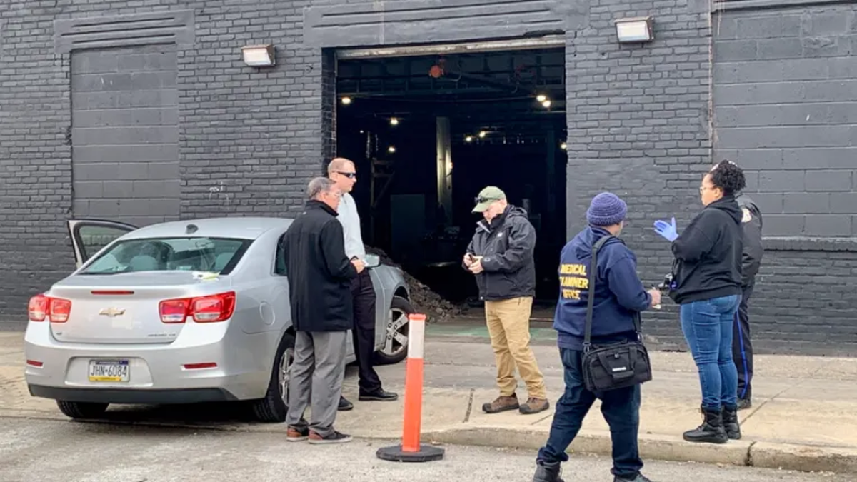 Police at the scene of a warehouse where a worker fel down an elevator shaft and died