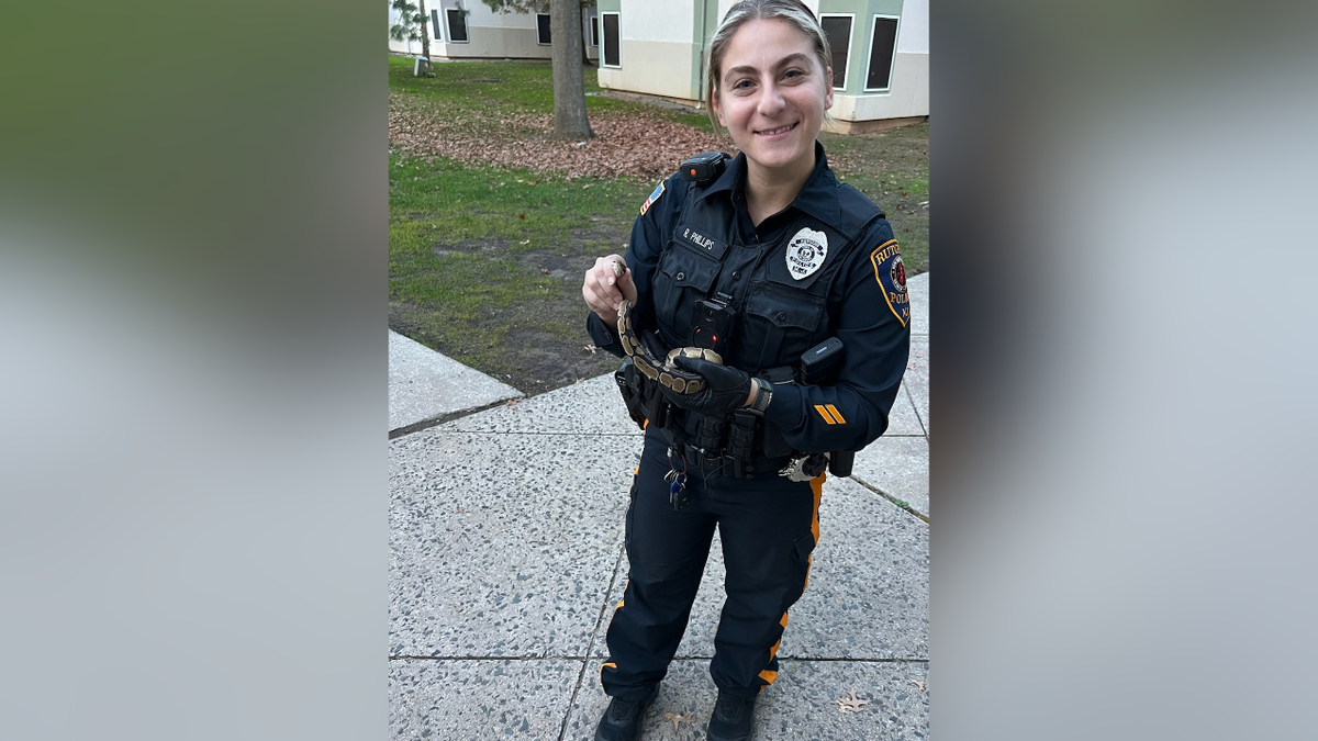 A police officer is pictured with a snake