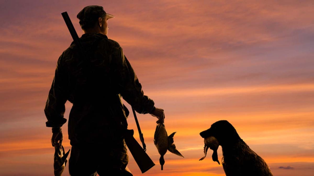 Hunter with waterfowl and dog