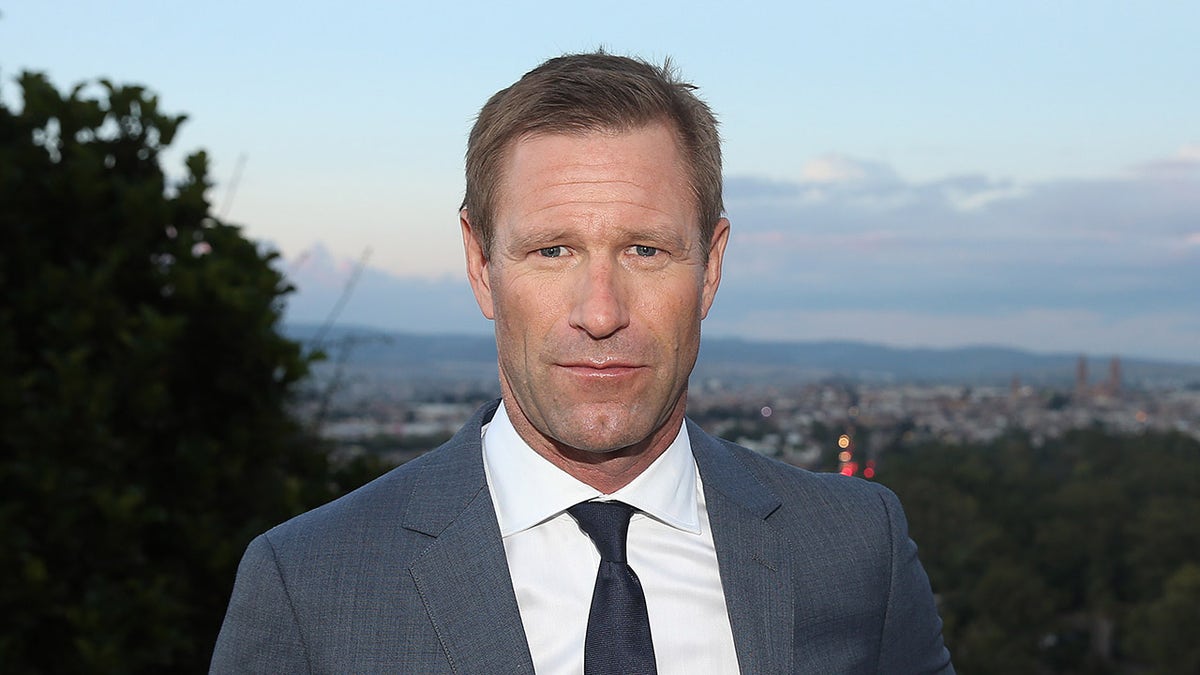 Aaron Eckhart poses during sunset