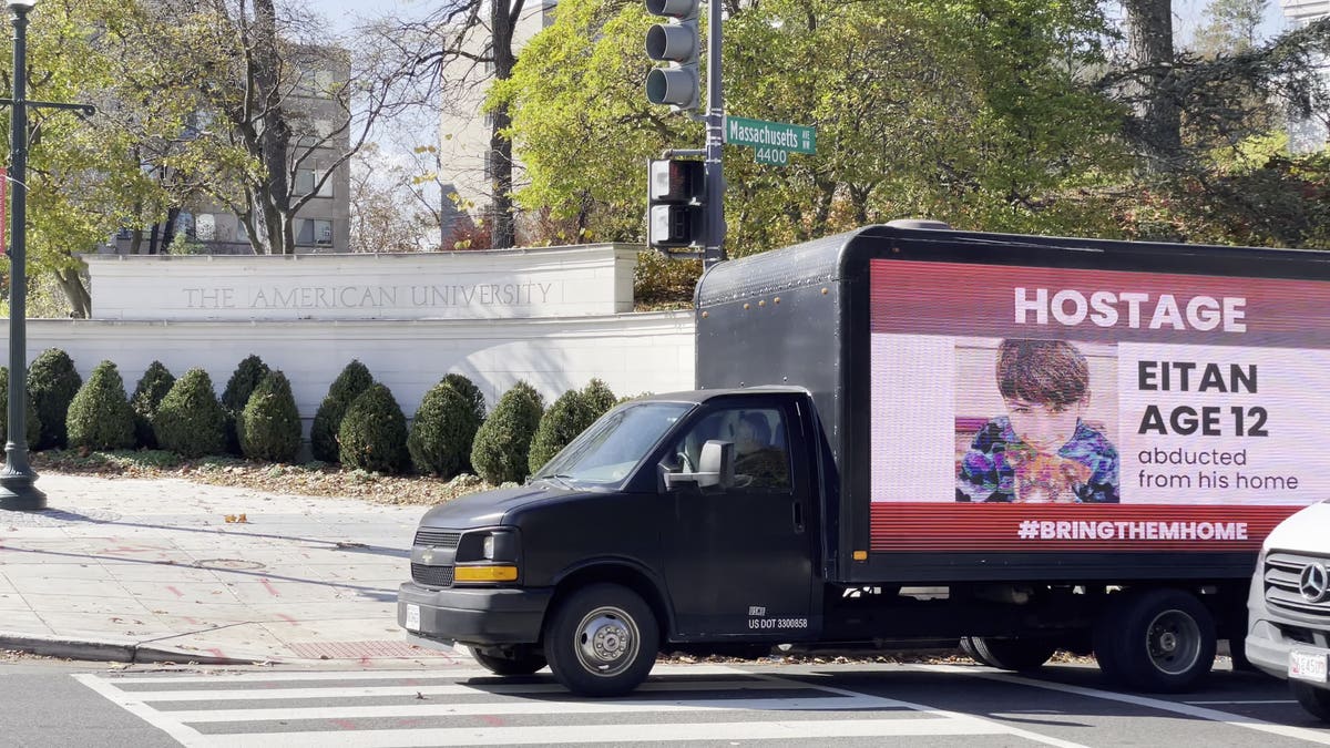 A truck displaying missing posters of Israelis drives outside of the American University campus