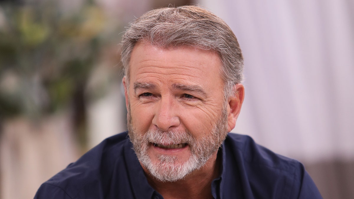 Bill Engvall in a blue long sleeve shirt sitting at Universal Studios
