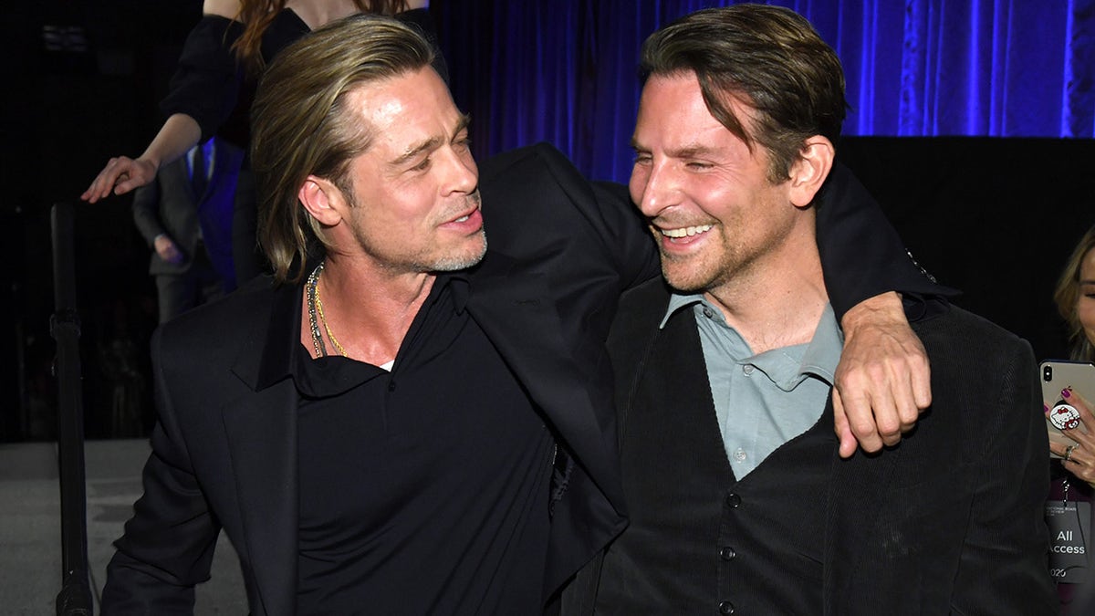 Brad Pitt wraps his arm around Bradley Cooper