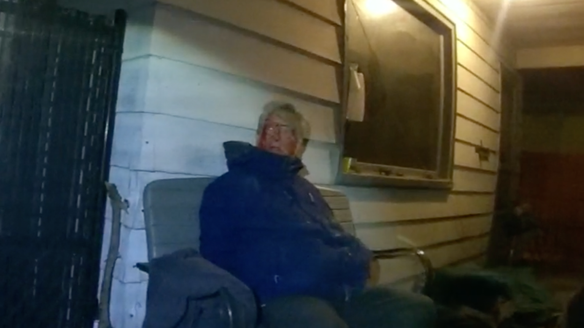 Rand Briem sits on his porch after police put him in handcuffs.