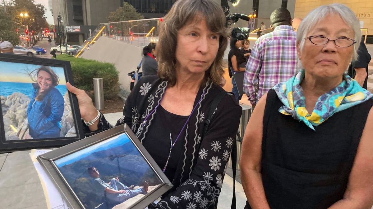 Vicki Moore, left, and Barbara Chan, sister, hold a photo of Vicki's husband and daughter Scott Chan, and daughter Kendra Chan, who died aboard the dive boat Conception