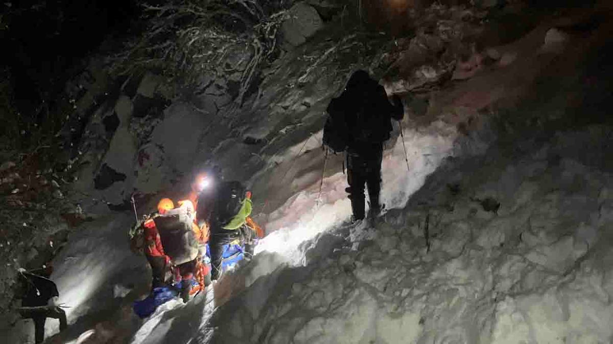 rescuers descending gully