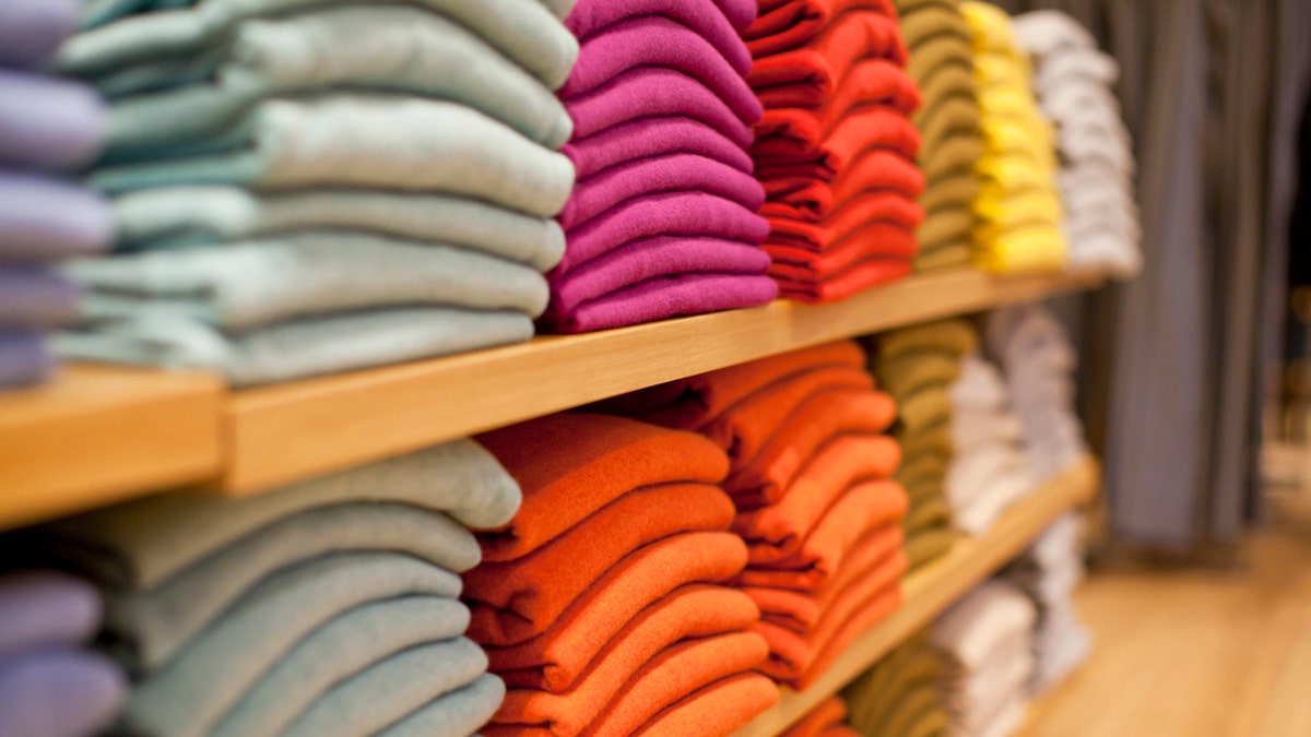 Colorful display of sweaters on shelf in store