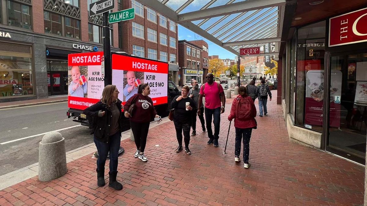 A truck bearing the names and photos of Israeli children held hostage by Hamas drives past Boston University