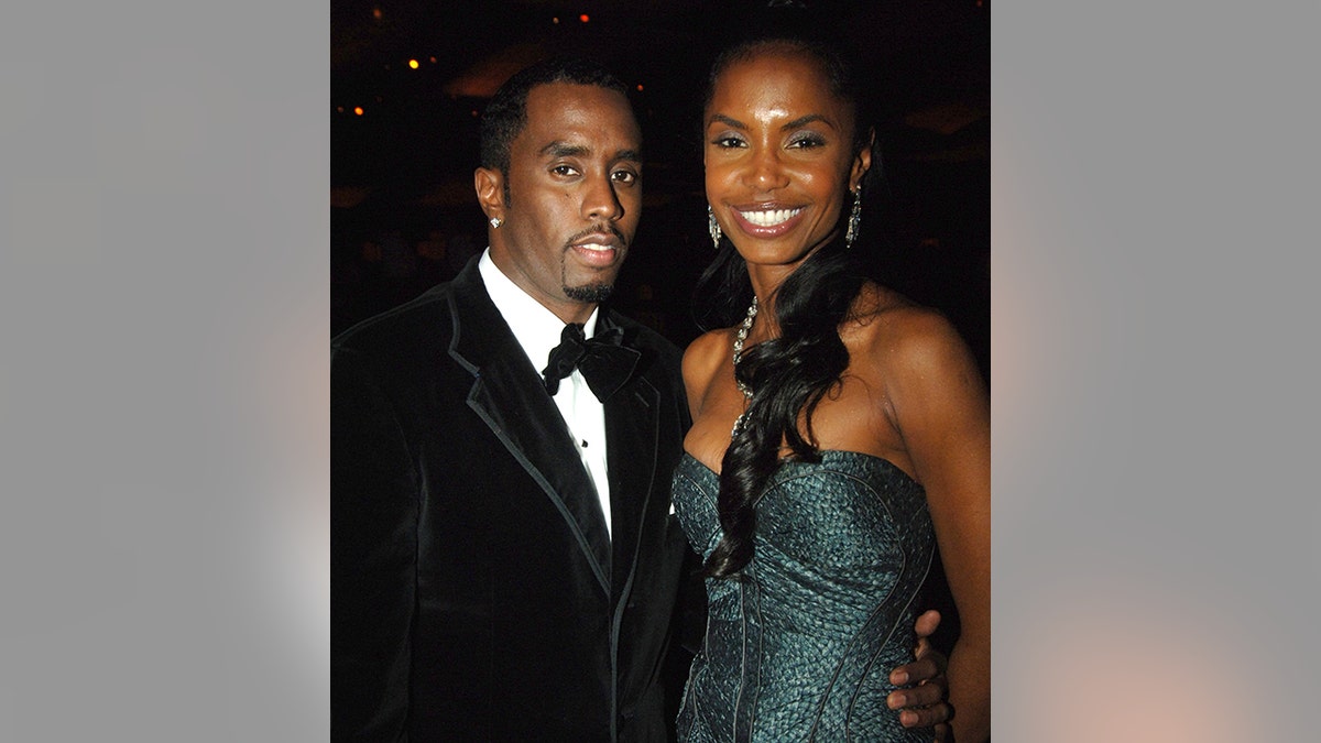 Diddy in a black tuxedo and Kim Porter in a dark green dress at the Academy Awards Governors Ball