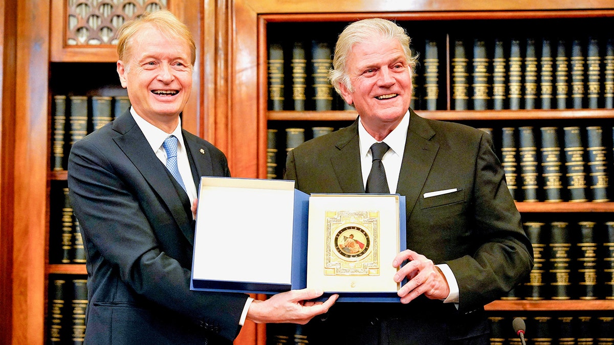 Franklin Graham and Italian senator holding document