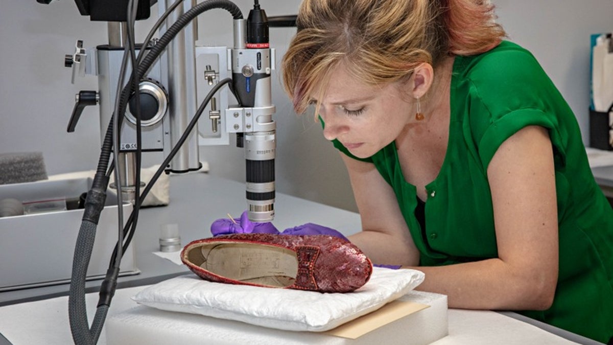 A conservator at the Smithsonian Institution's National Museum of American History analyzes one of the recovered ruby slippers worn in the "Wizard of Oz"