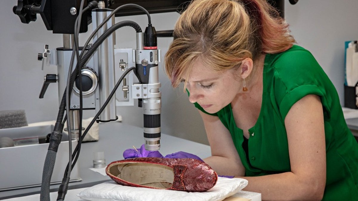 A conservator at the Smithsonian Institution's National Museum of American History analyzes one of the recovered ruby slippers worn in the "Wizard of Oz"