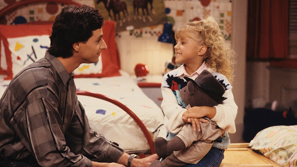 Bob Saget sits down and looks at Jodie Sweetin on the set of "Full House" in character as Danny and Stephanie Tanner