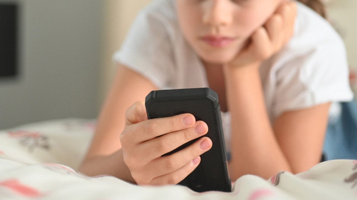 Young girl looks at smartphone