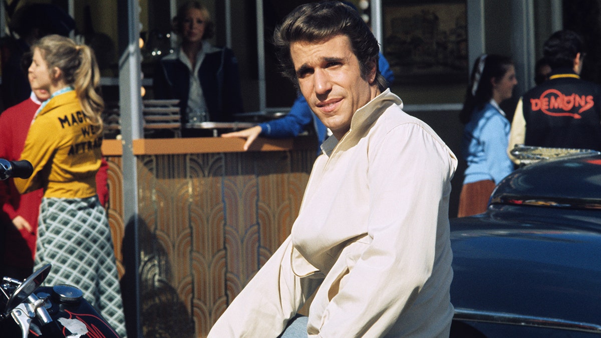 Henry Winkler as 'The Fonz' leaning against a car in "Happy Days"