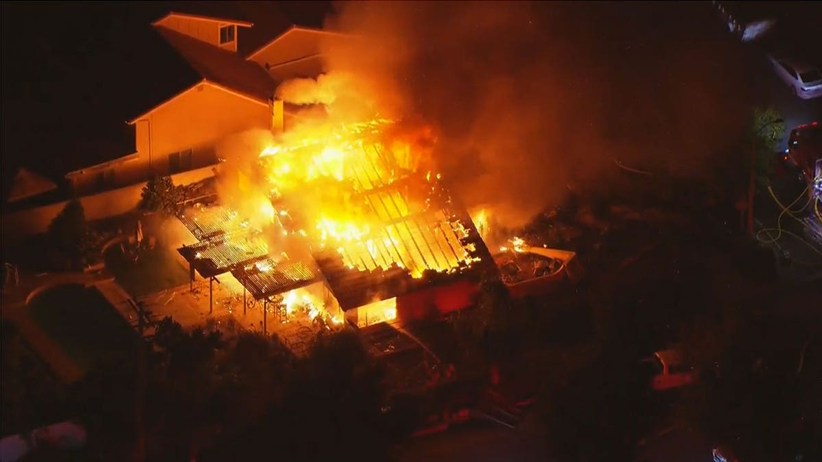 une photo aérienne d'une maison en feu dans les hautes terres de Californie